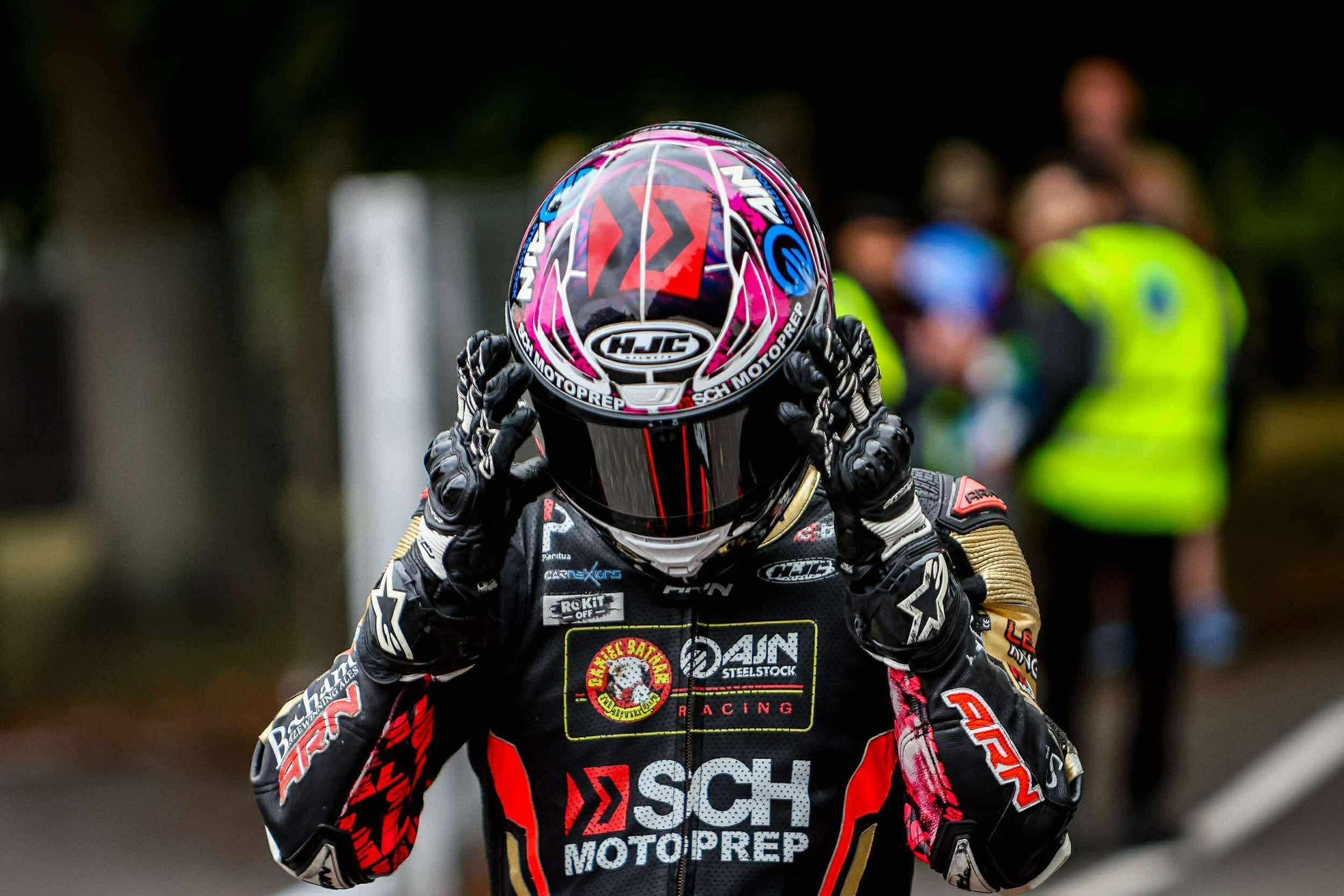 Christian Smith adjusting his helmet visor in race leathers