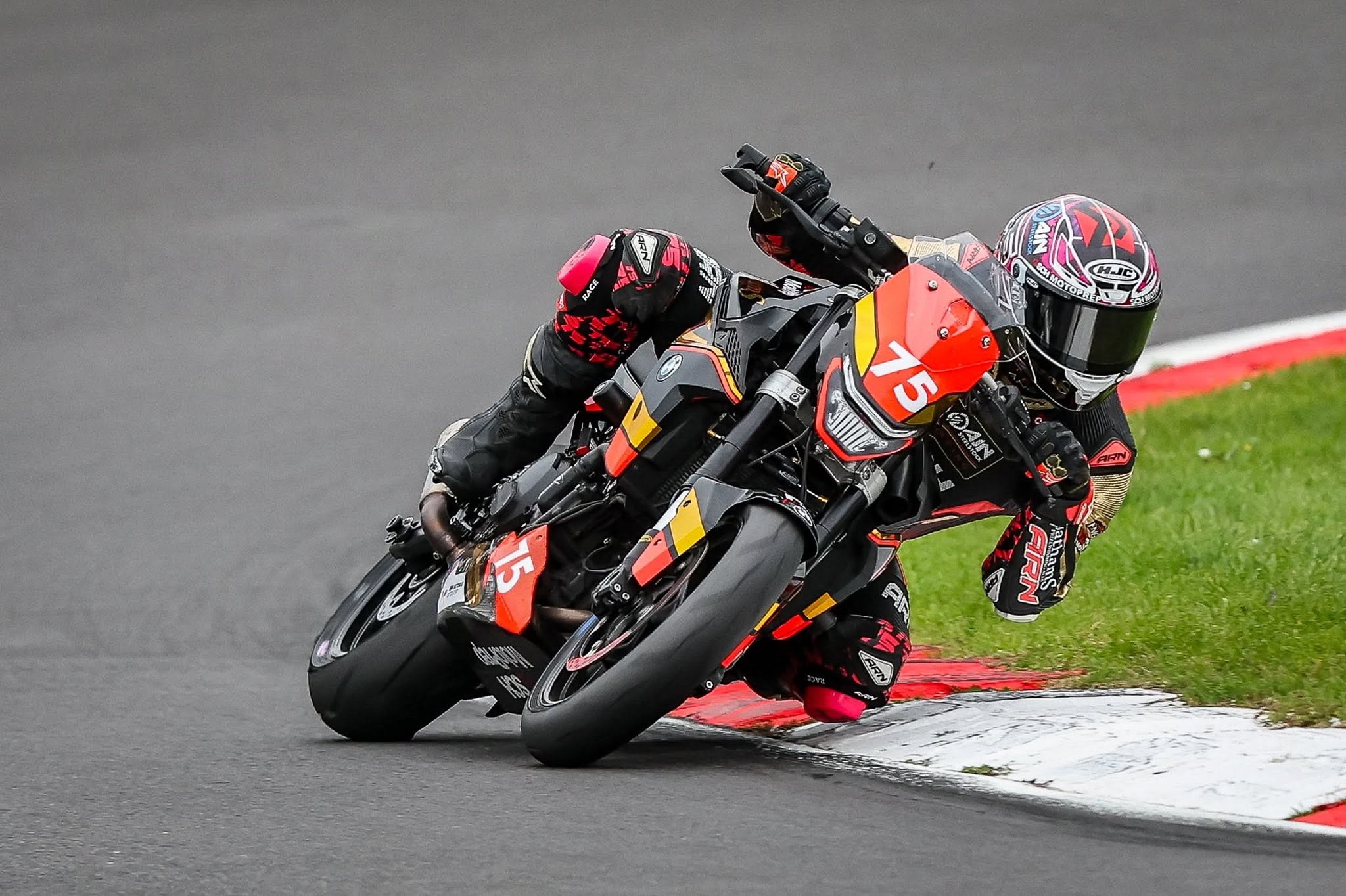 Christian Smith riding number 75 hard on the edge through a corner