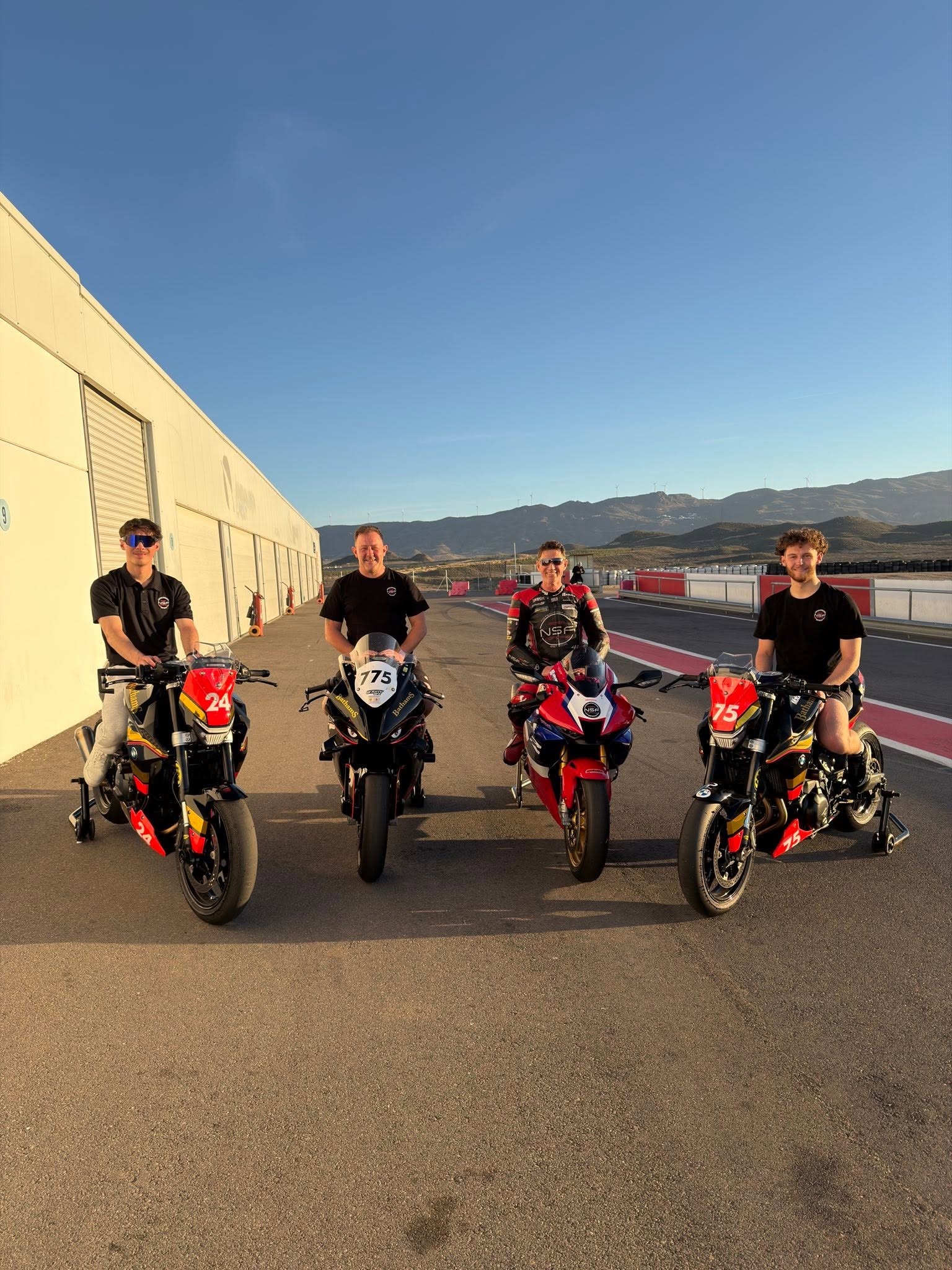 Smith Twins riders and team lined up with race bikes in the paddock