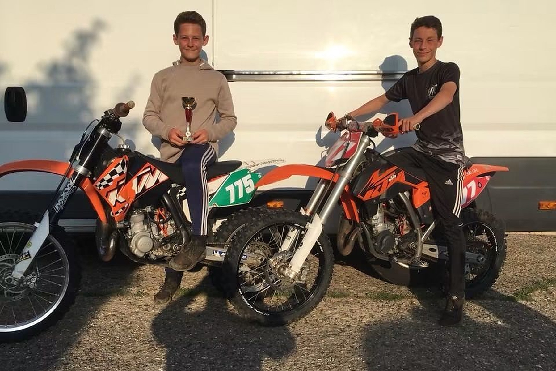 Christian Smith holding his first motorcycle trophy alongside Kieran and their bikes