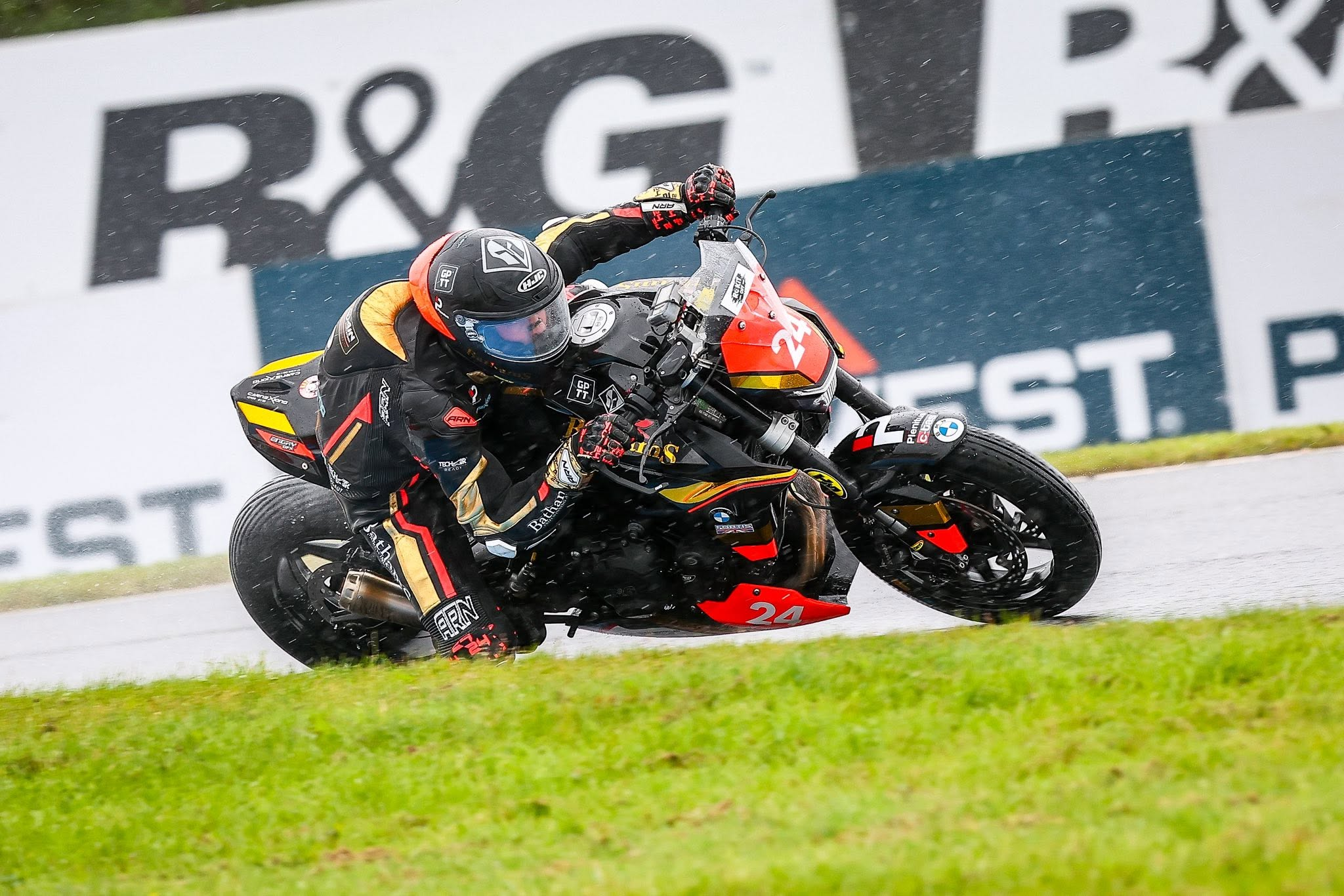 Kieran Smith leaning number 24 through a wet right-hand corner on track