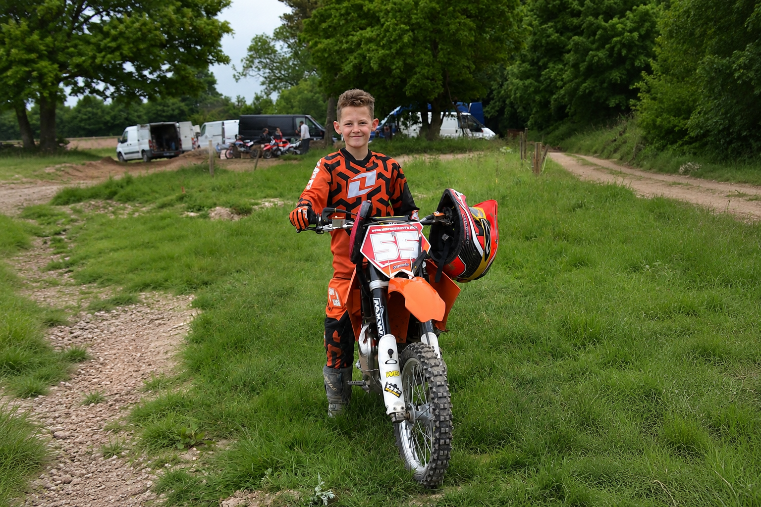 Young rider standing with a dirt bike