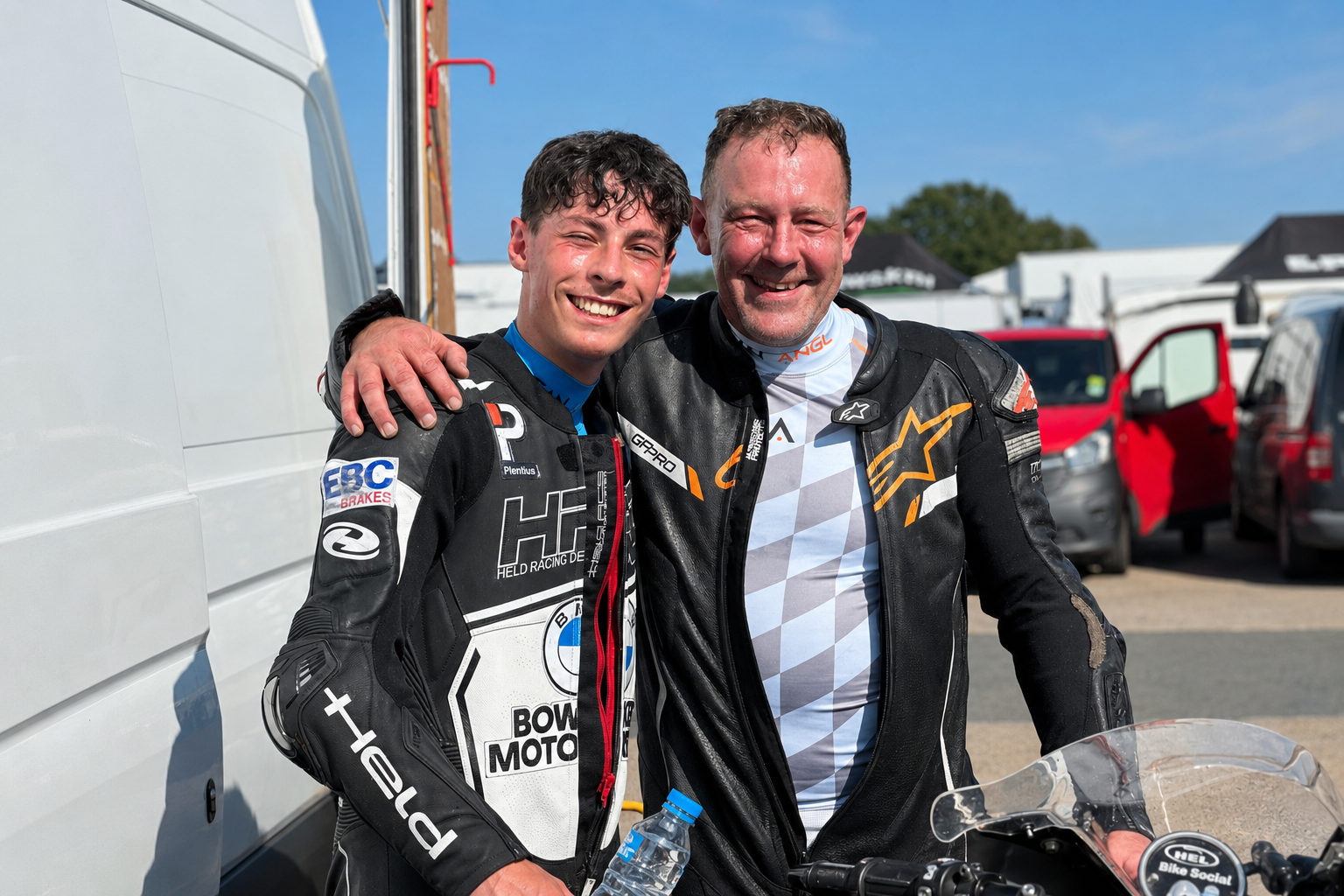 Two riders smiling in the paddock