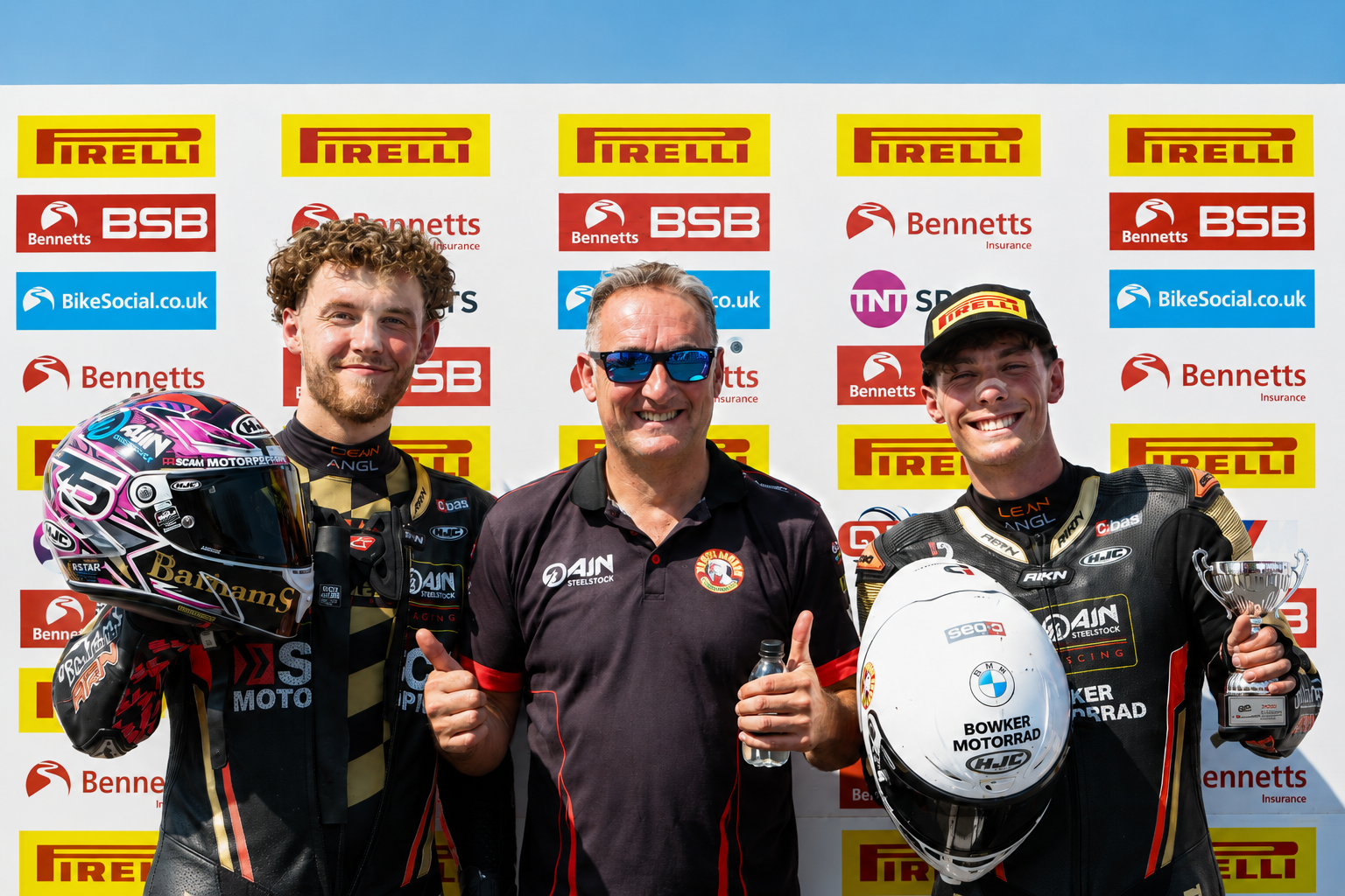 Smith Twins riders with team member at podium backdrop