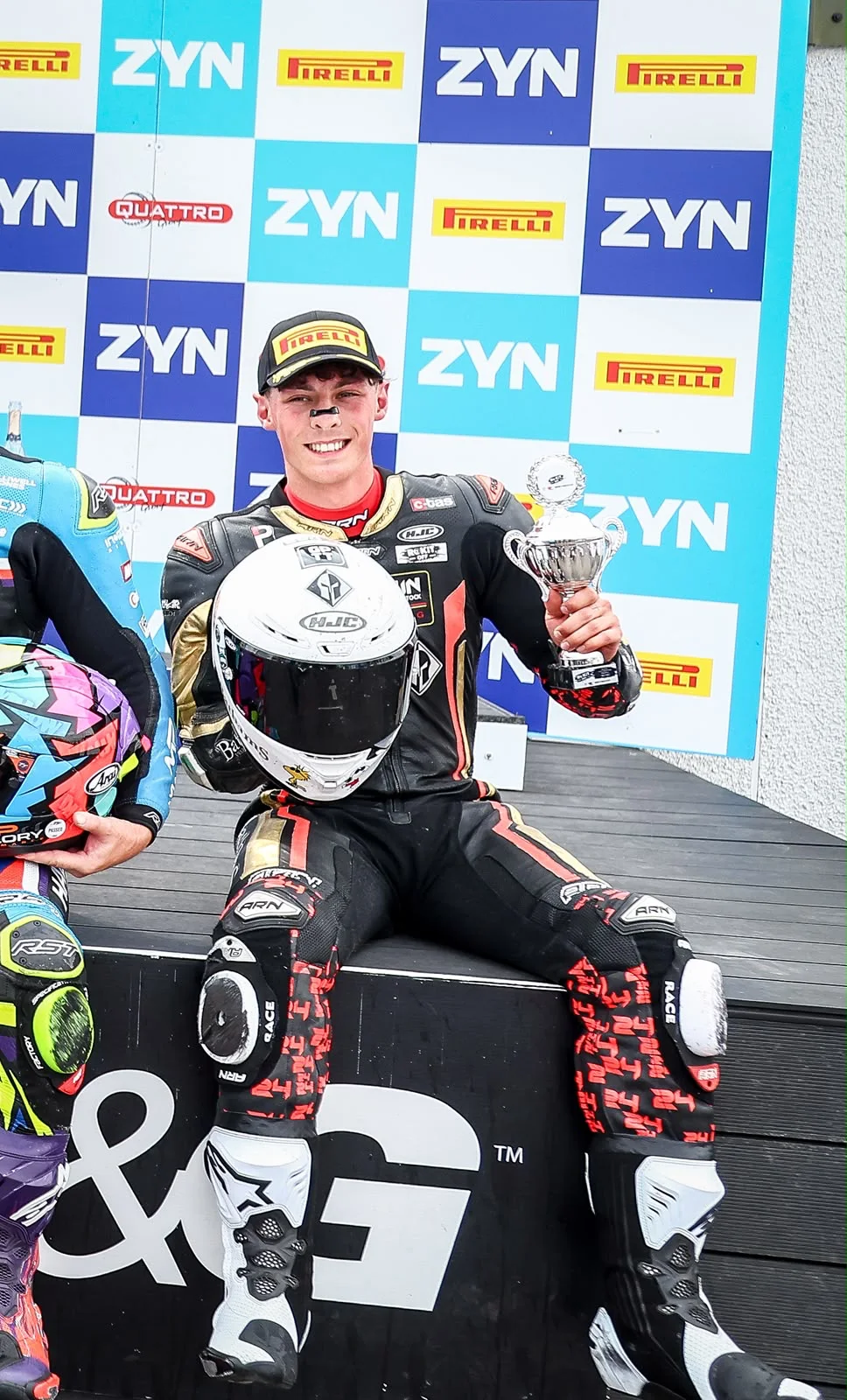 Kieran Smith seated on the Thruxton podium holding his third-place trophy